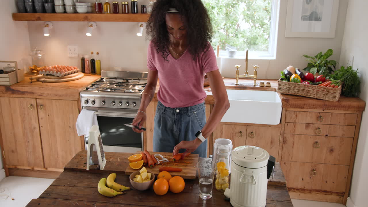 Preparando suco fresco, mulher fatiando cenouras em uma cozinha iluminada, com foco na saúde, em casa