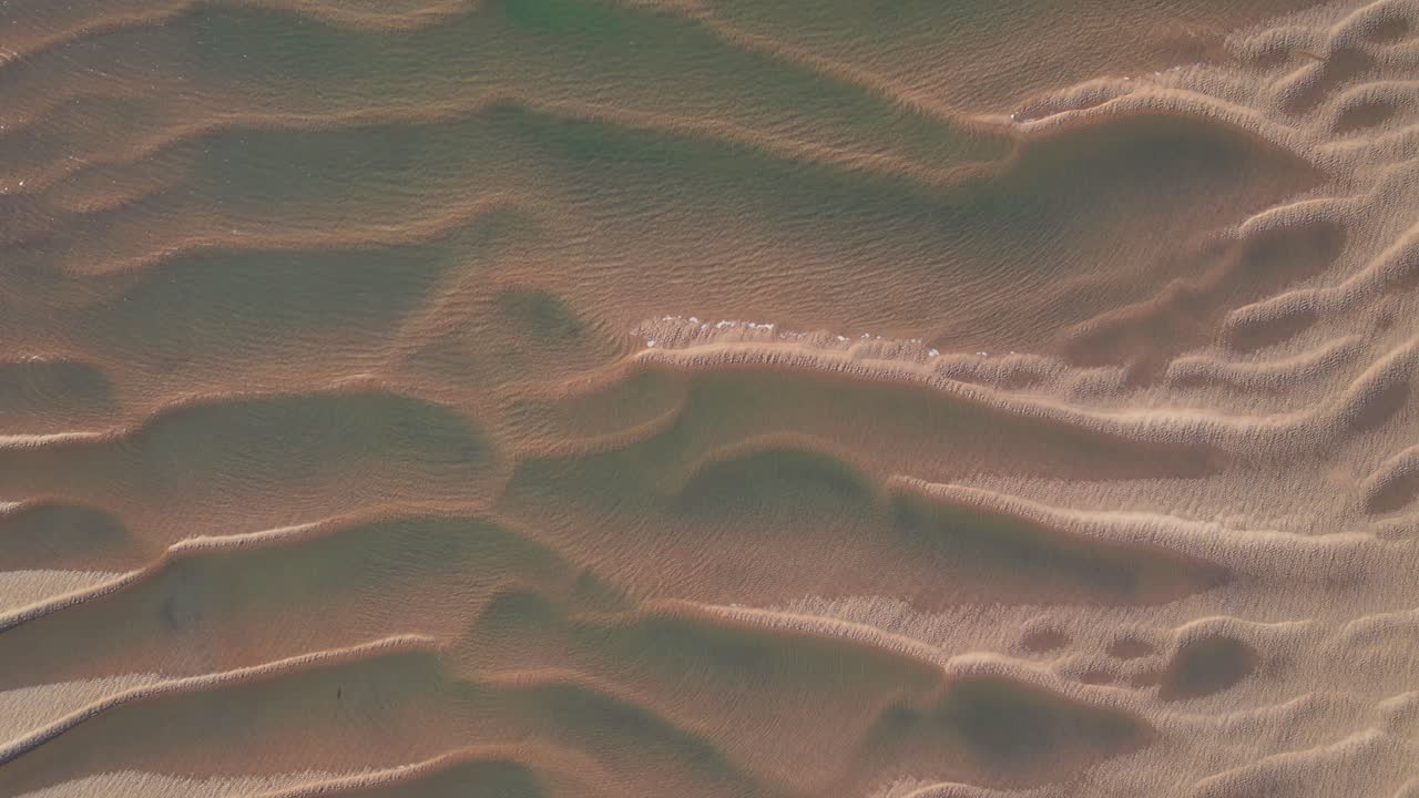 바람과 물 잔물결이 있는 썰물 때 모래 형성의 드론 보기