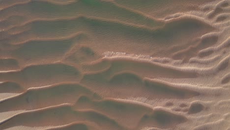 drone view of sand formation at low tide with wind and water ripples