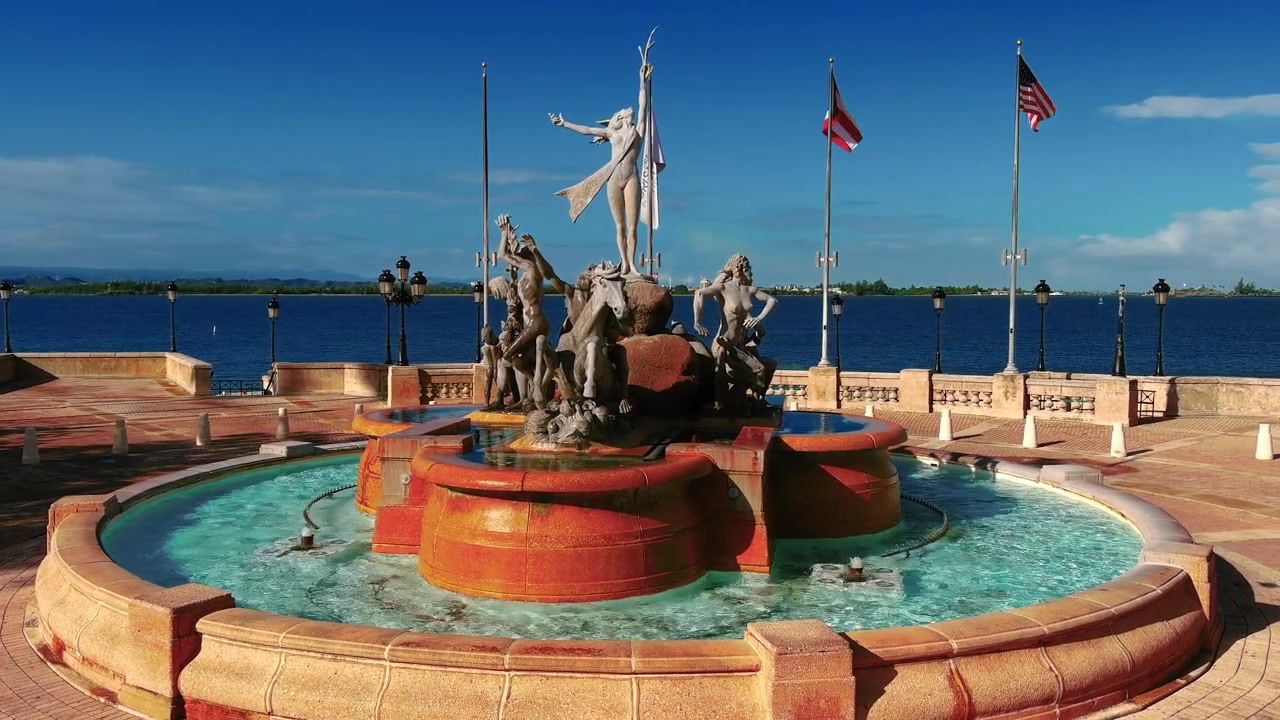 Paseo de la Princesa, Eski San Juan, PR'deki Raices Çeşmesi'nin 4K sola kaydırmalı drone çekimi. Çeşme ve Atlantik Okyanusu manzarasını gösterir. Turizm, kültür, emlak için