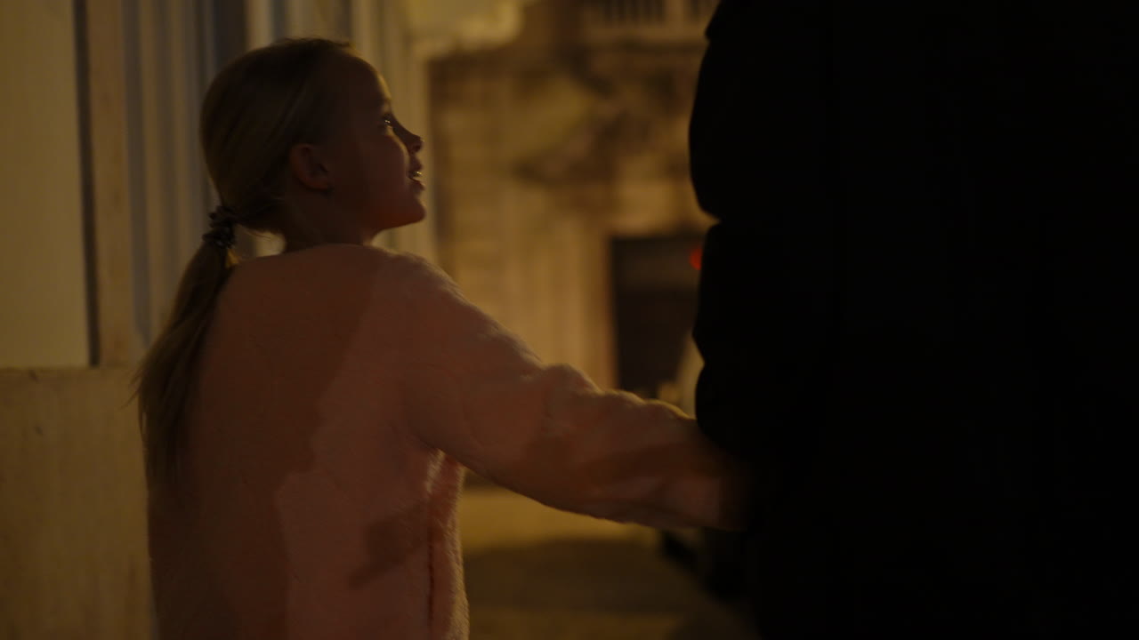 Little Girl Holding Parent Hand Walking in Dark Hallway