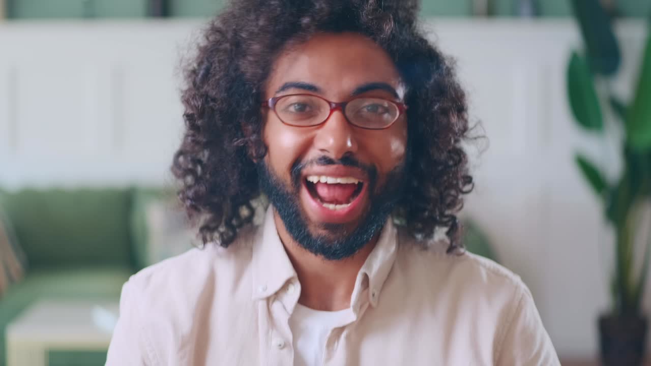 Vista dalla telecamera: giovane uomo arabo attivo, freelance, parla in videoconferenza.