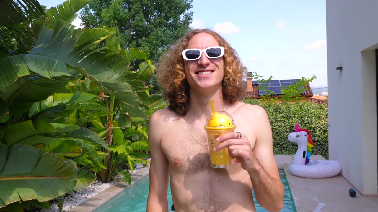 Jovem Sorridente com Cabelo Cacheado Tomando Smoothie à Beira da Piscina