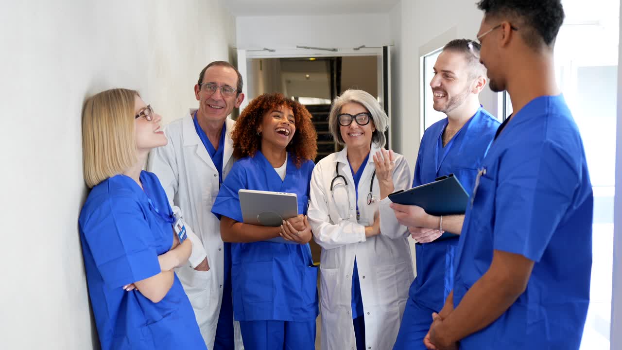 Diverse Group of Medical Professionals Talking and Laughing in Hospital Hallway
