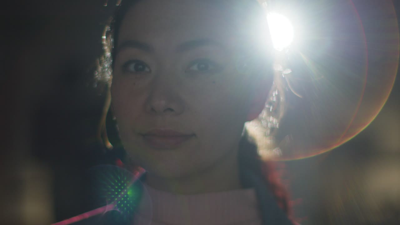 프로젝터 4의 빛에 의해 백라이트 된 몰입 예술 전시회를 방문하고 상호 작용하는 여성의 클로즈업