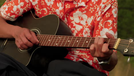 asian musician playing guitar, closeup slow-motion