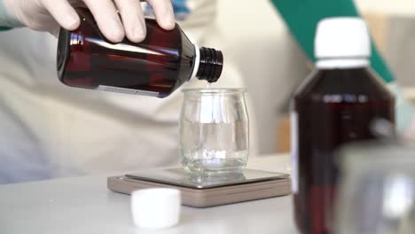 Pouring-and-weighing-glycerin-on-a-beaker-glass-to-create-hand-crafted-soap-bars,-Close-up-shot