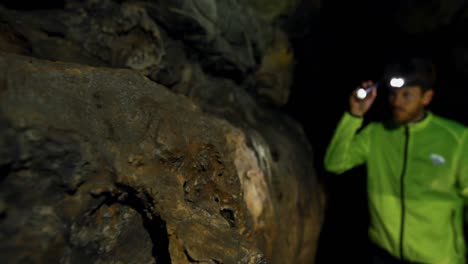 male hiker exploring a dark cave 4k