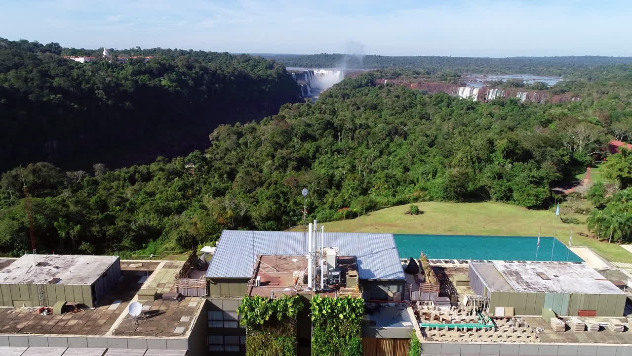 A drone unveiling the Meli&aacute; hotel with the Iguazu Falls in the background, offering a breathtaking view of this magnificent natural wonder