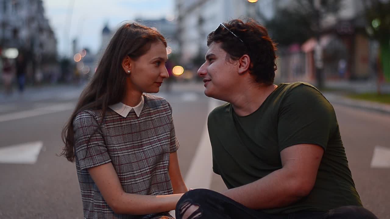 Young couple kissing in the middle of the street at sunset. Lovely caucasian couple showing love on the street and they are happy together. Close up shot.