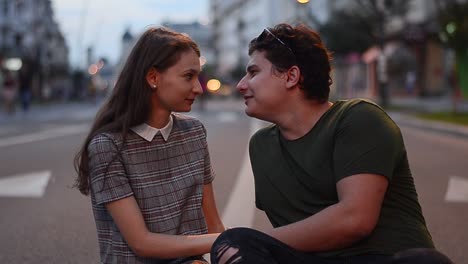 young couple kissing in the middle of the street at sunset. lovely caucasian couple showing love on the street and they are happy together. close up shot.
