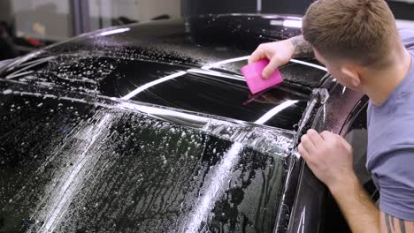 man covering car with vinyl polyurethane tape. films for the car. sticker protective film on the car