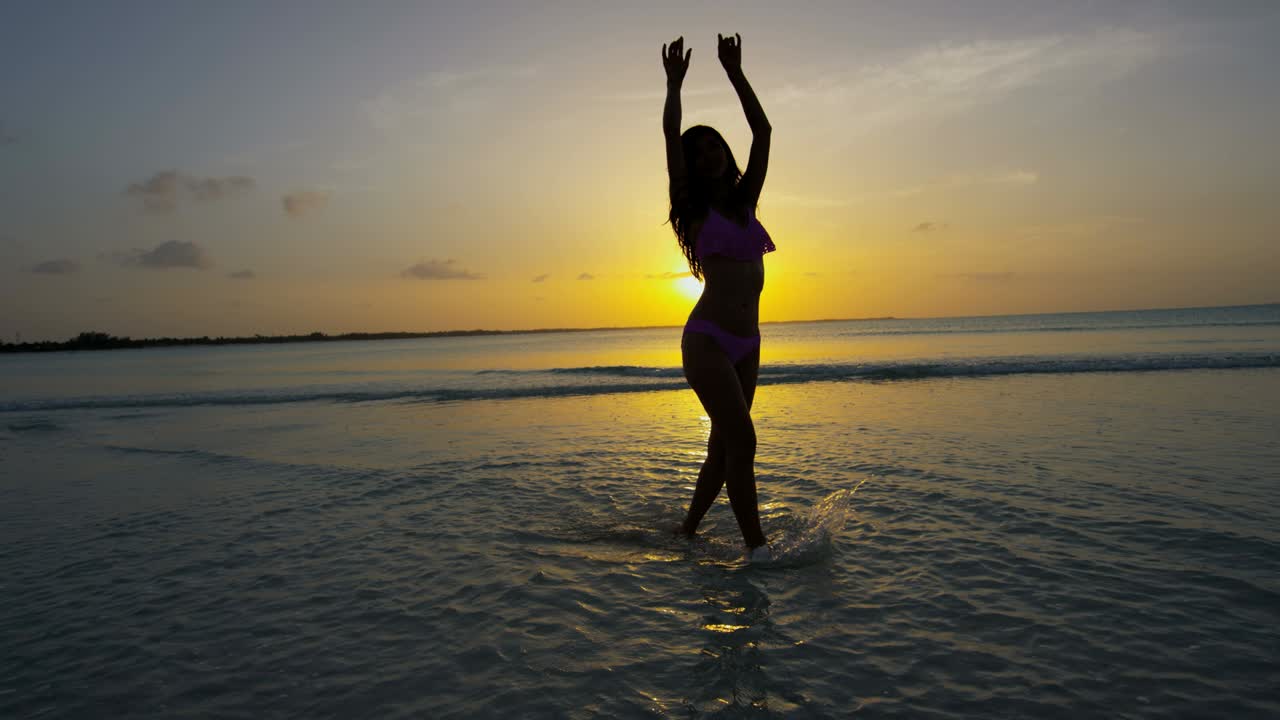 vista del atardecer de una chica china asiática en la playa