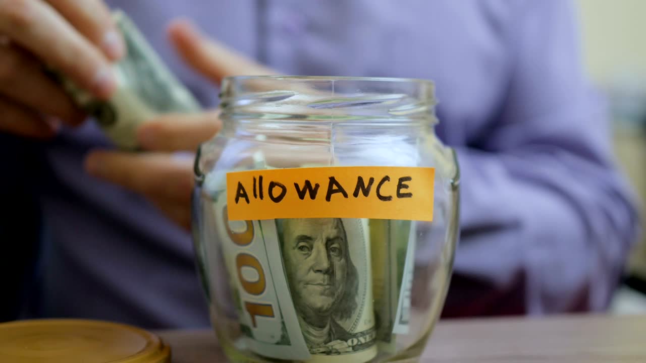 백인 남자가 유리 항아리를 넣고 그의 저축금과 함께 서랍 테이블에 넣습니다.