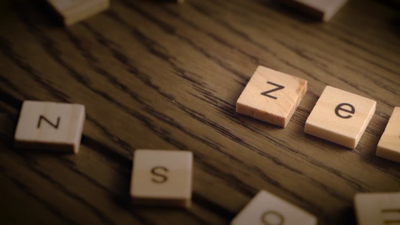 Wooden tiles spell the word zen as the camera pans slowly across a rustic wood surface with warm lighting.