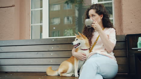woman with shiba inu enjoying coffee outside a cafe
