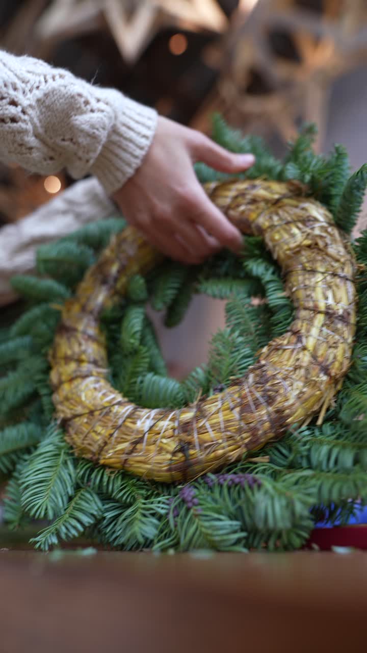 mujer haciendo una corona de paja de navidad