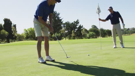 Two-caucasian-senior-man-practicing-golf-at-golf-course-on-a-bright-sunny-day