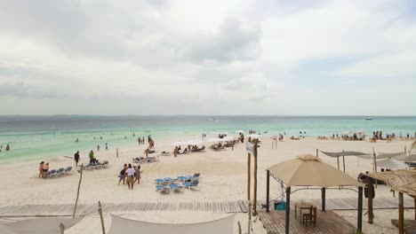 Tropische-Seelandschaft-Mit-Leuten,-Die-Den-Schönen-Strand-Und-Sand-Von-Playa-Indios-Auf-Der-Isla-Mujeres,-Mexiko-Genießen---Breite-Aufnahme