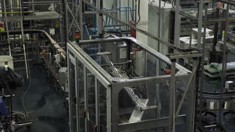 machine putting six pack rings on aluminium cans in large packaging factory