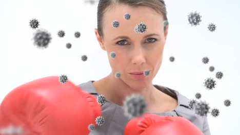 Animation-of-virus-cells-floating-over-caucasian-female-boxing