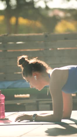mujer haciendo ejercicio de tabla al aire libre