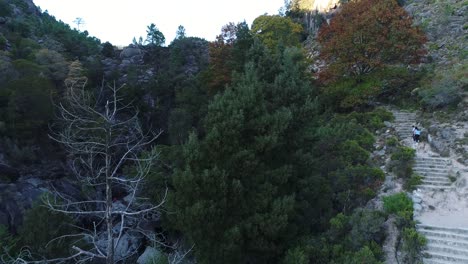 lovers climbing the mountain stairs towards the waterfall