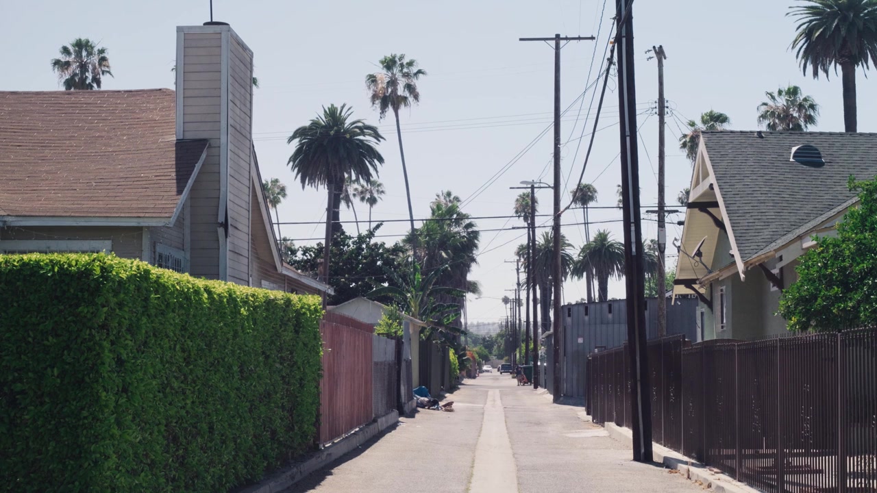 Vicolo pulito e tranquillo a Los Angeles, ripresa grandangolare statica, scena urbana residenziale diurna e soleggiata.