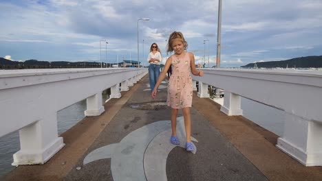 mother and daughter enjoying a stroll on a pier