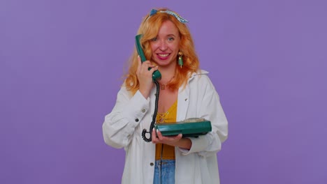 Cheerful-redhead-girl-secretary-talking-on-wired-vintage-telephone-of-80s,-says-hey-you-call-me-back