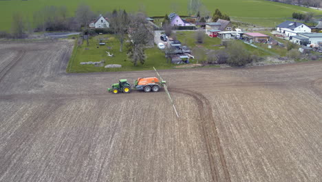 un tractor rociando fertilizante en un campo