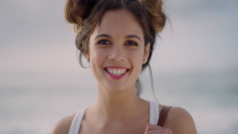 portrait of happy young woman smiling cheerful running hand through hair enjoying carefree lifestyle on ocean seaside background
