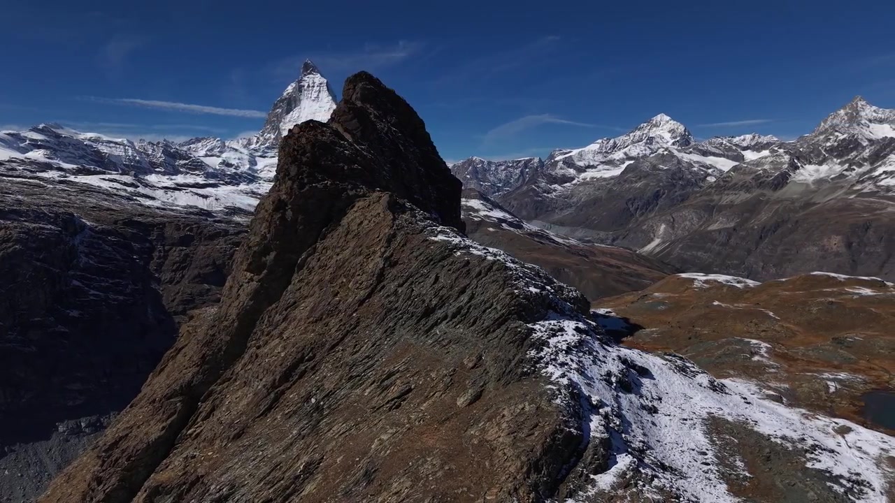 スイスのツェルマット、ゴルナーグラートのリッフェルホルン上空を飛行し、有名なアルプスの山頂マッターホルンが姿を現す空撮
