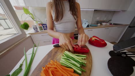 woman chopping fresh vegetables for a healthy meal in a kitchen
