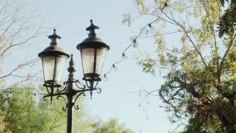 Streetlights-strung-with-lights,-panning-shot