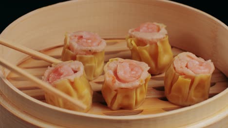 various of dim sum on wooden steamer close-up macro. steaming technique. chinese dessert food. dimsum with shrimps, fish and meat. dish in a cafe. homade. delivery
