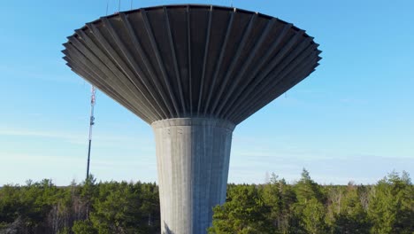 water tower surrounded by trees. ascending drone shot