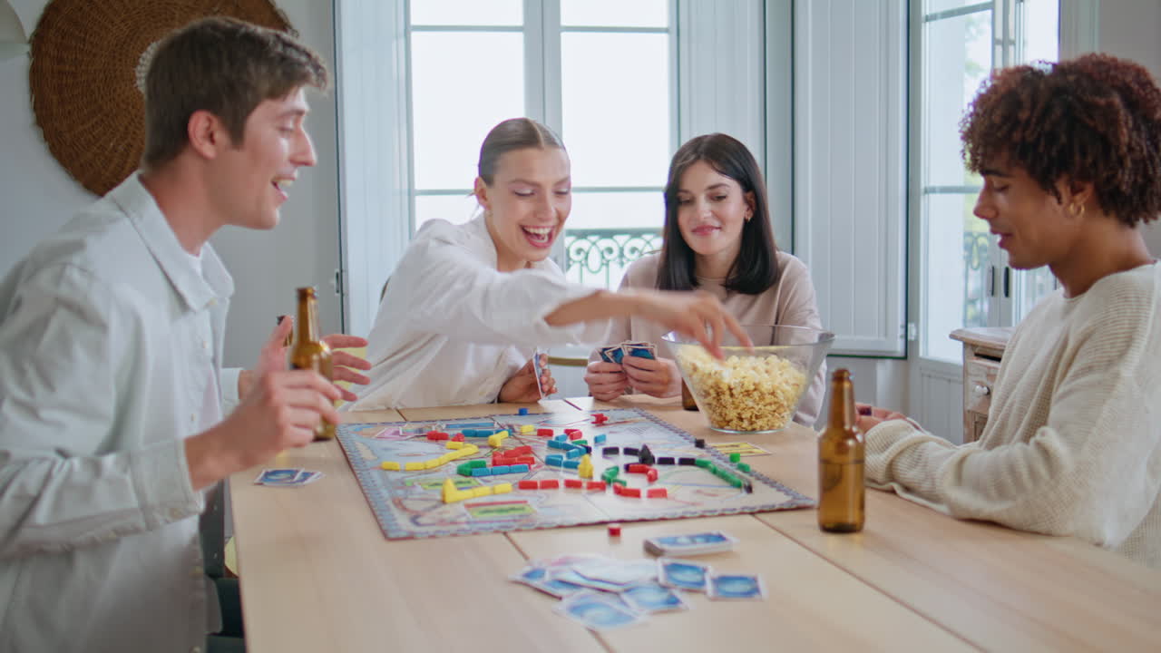 Laughing youngsters playing cards kitchen closeup. Friends enjoying board game