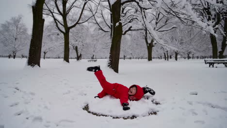 child playing in the snow in a park