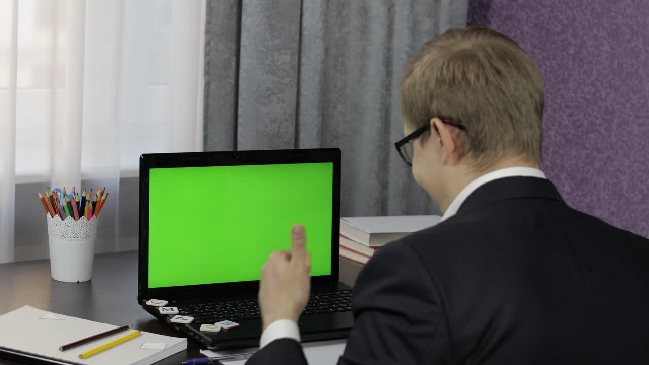 hombre haciendo una llamada de video en línea en una computadora portátil. pantalla verde. educación a distancia