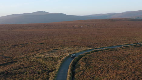 aerial view, follow shot, 4k, drone footage following a car driving on a mountain road