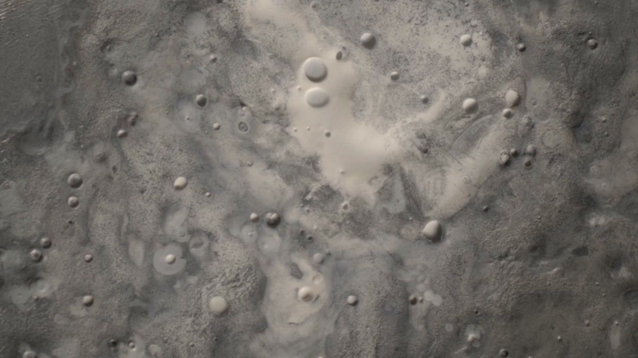 Surface of the moon simulation featuring rotating grey craters of various sizes. Top-down cinematic view with soft light creating a mysterious atmosphere for space exploration content.