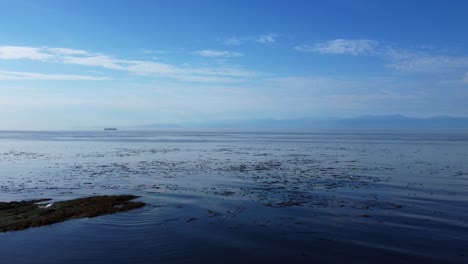 British-Colombia-Pacific-Coast-West-Canada-ocean-water,-land-in-horizon,-aerial