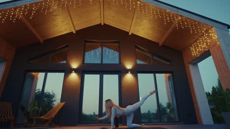 woman doing yoga outdoors on a patio at night.