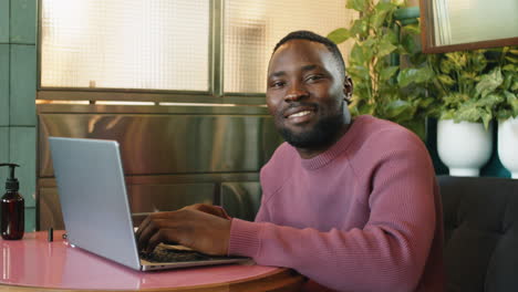 Porträt-Eines-Fröhlichen-Afroamerikanischen-Mannes-Mit-Laptop-Im-Café