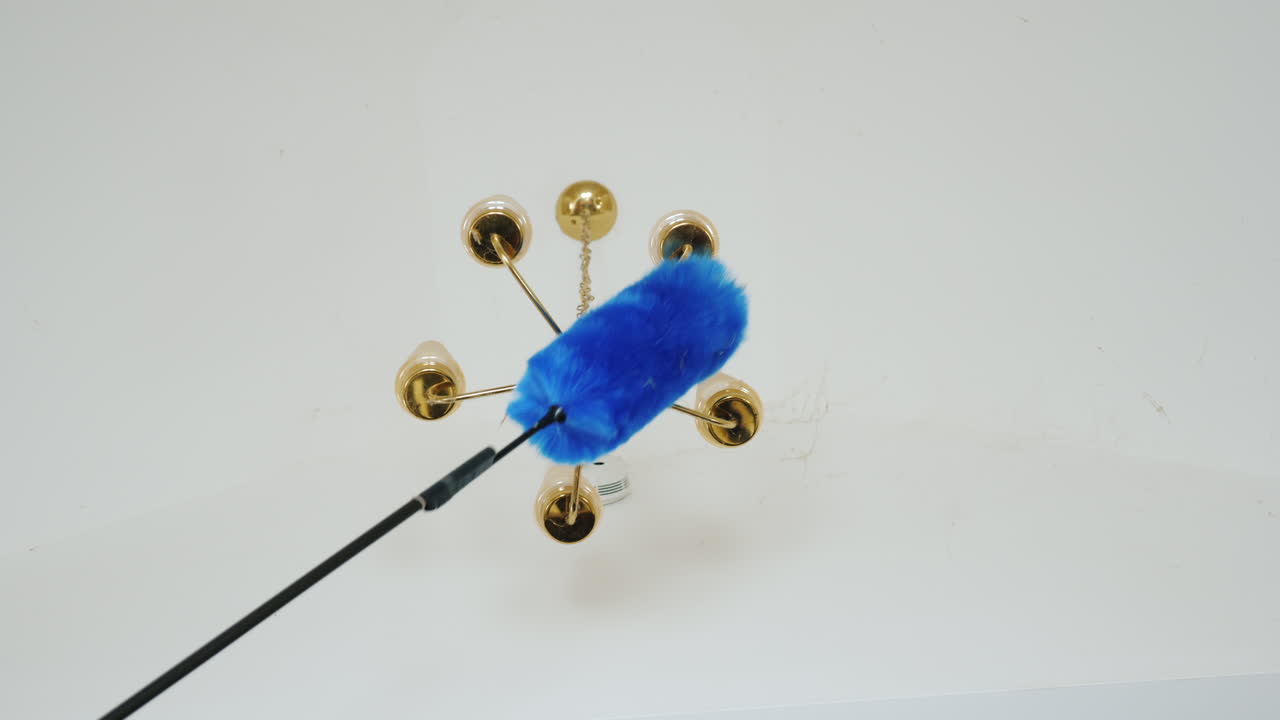 한 여자가 샹들리에 큰 집 청소 근처 천장에 있는 거미줄과 파편을 청소합니다