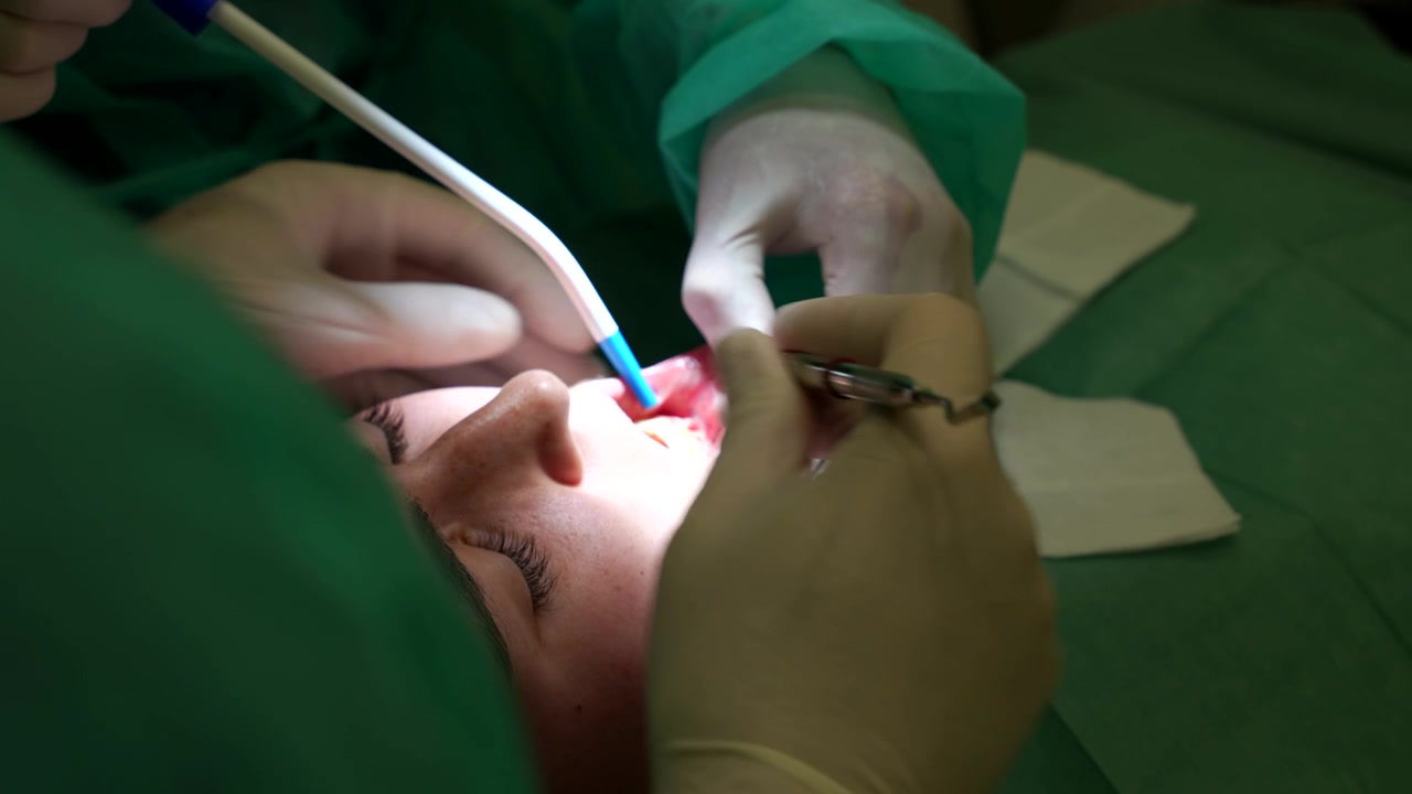 Dentist and assistant performing oral surgery with focus and patient care