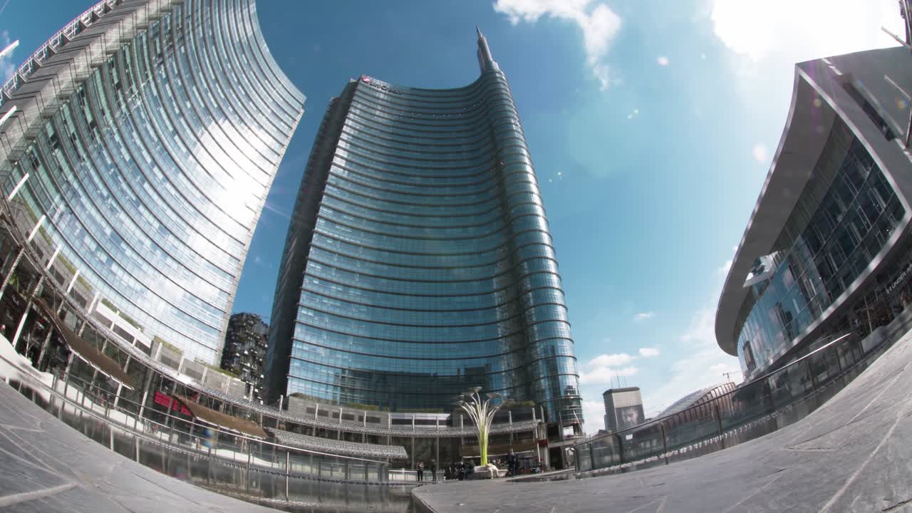 el lapso de tiempo de los edificios de vidrio curvos de la ciudad de milán en la moderna plaza de la ciudad comercial del centro de la ciudad. italia