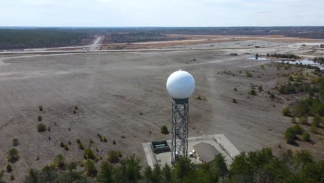 weather radar, aerial drone shot around a weather detection turret next to a forest