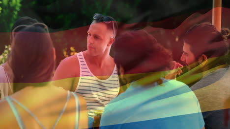 grupo de amigos socializando al aire libre con la animación de la bandera alemana sobre ellos
